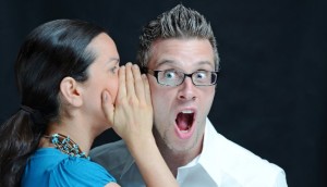 Woman whispers in Man's ear - surprise